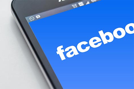 Ein Handydisplay zeigt das Logo von Facebook
